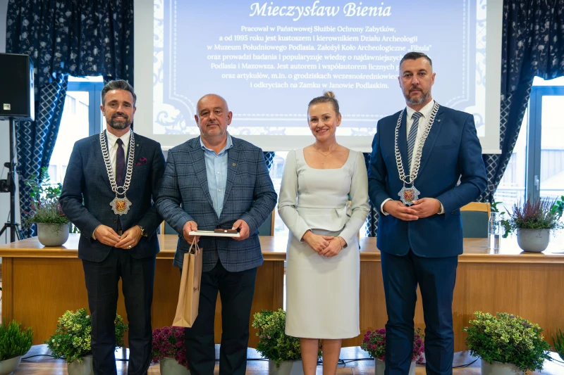 Uczestnicy uroczystości wręczenia wyróżnień stojący wspólnie do zdjęcia grupowego.