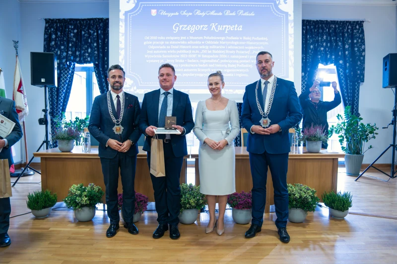 Uczestnicy uroczystości wręczenia wyróżnień stojący wspólnie do zdjęcia grupowego.