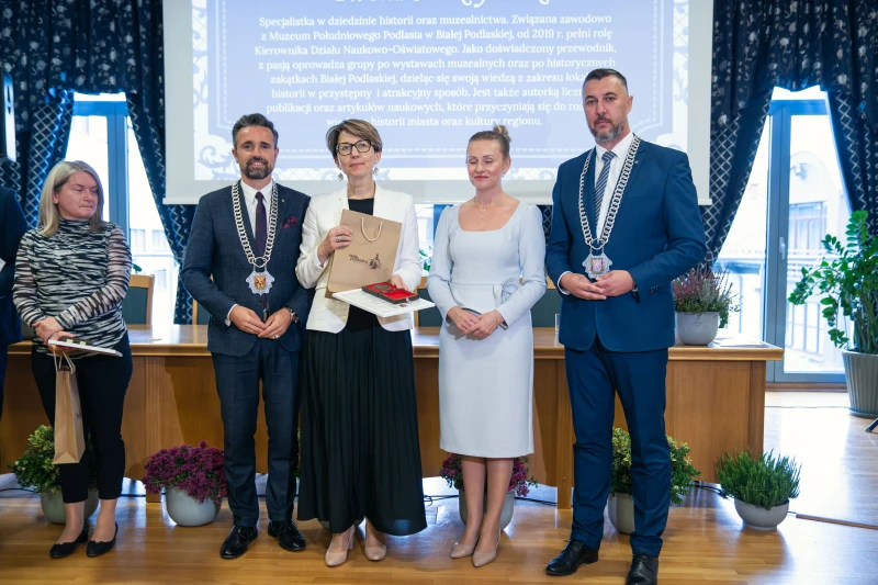 Uczestnicy uroczystości wręczenia wyróżnień stojący wspólnie do zdjęcia grupowego.