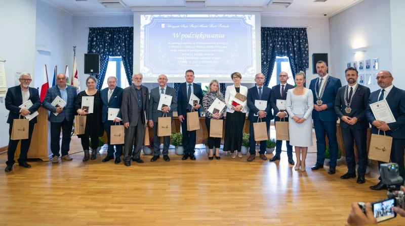 Grupowe zdjęcie osób wyróżnionych podczas uroczystości wręczenia podziękowań w sali konferencyjnej.