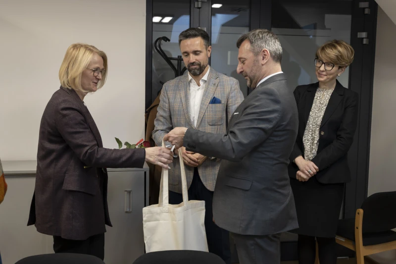 Wręczenie czerwonej róży i białej torby kobiecie przez dyrektora muzeum