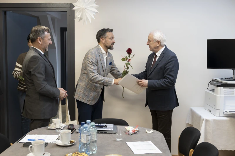 Wręczenie róży starszemu mężczyznie przez prezydenta miasta