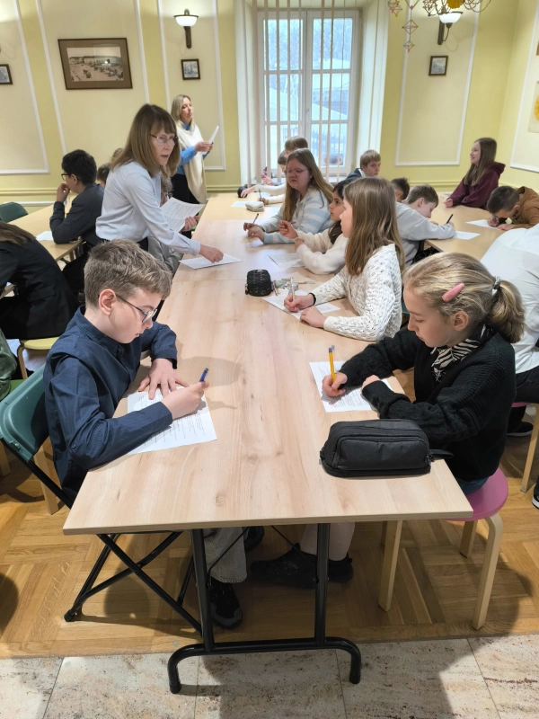 Uczniowie siedzą przy stołach; skupiona praca indywidualna.