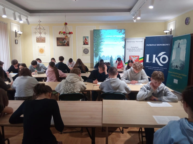 Uczniowie siedzą przy stołach; skupiona praca indywidualna.