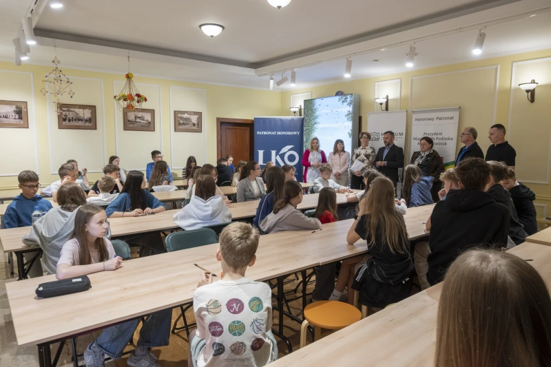 Grupa uczestników konkursu „Mój Region” słucha organizatorów podczas wydarzenia w muzeum.