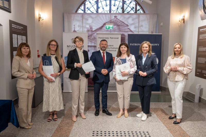 Wręczenie nagrody uczestnikowi konkursu w sali muzealnej.