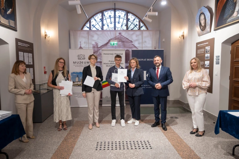 Wręczenie nagrody uczestnikowi konkursu w sali muzealnej.
