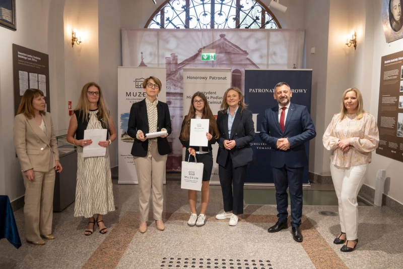 Wręczenie nagrody uczestnikowi konkursu w sali muzealnej.