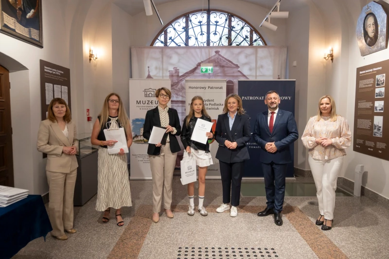 Wręczenie nagrody uczestnikowi konkursu w sali muzealnej.
