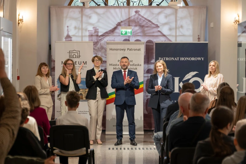 Wręczenie nagrody uczestnikowi konkursu w sali muzealnej.