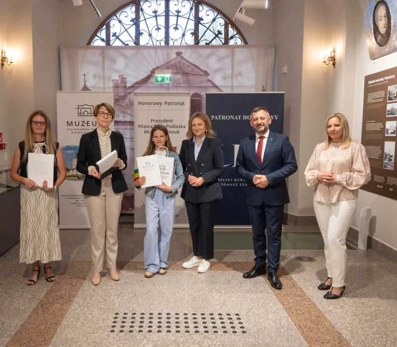 Wręczenie nagrody uczestnikowi konkursu w sali muzealnej.