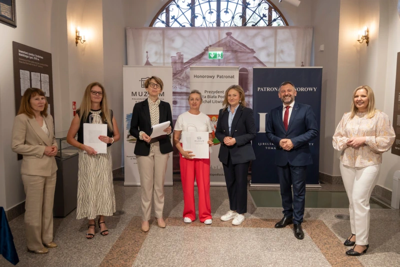 Wręczenie nagrody uczestnikowi konkursu w sali muzealnej.