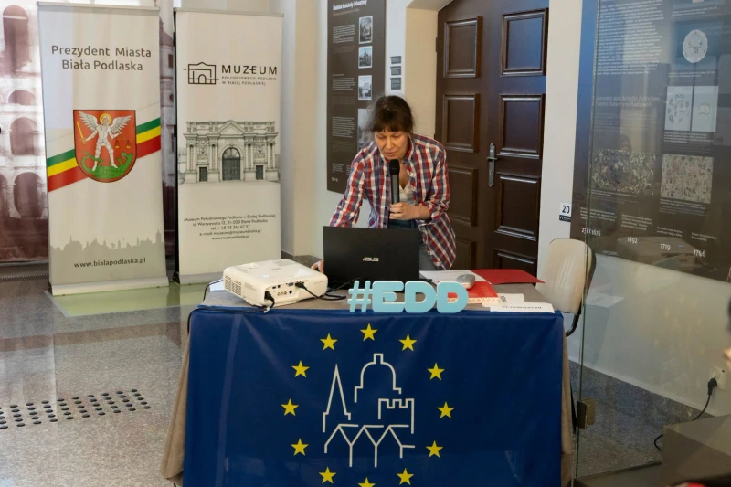 Kobieta prowadzi prezentację przy laptopie i projektorze.